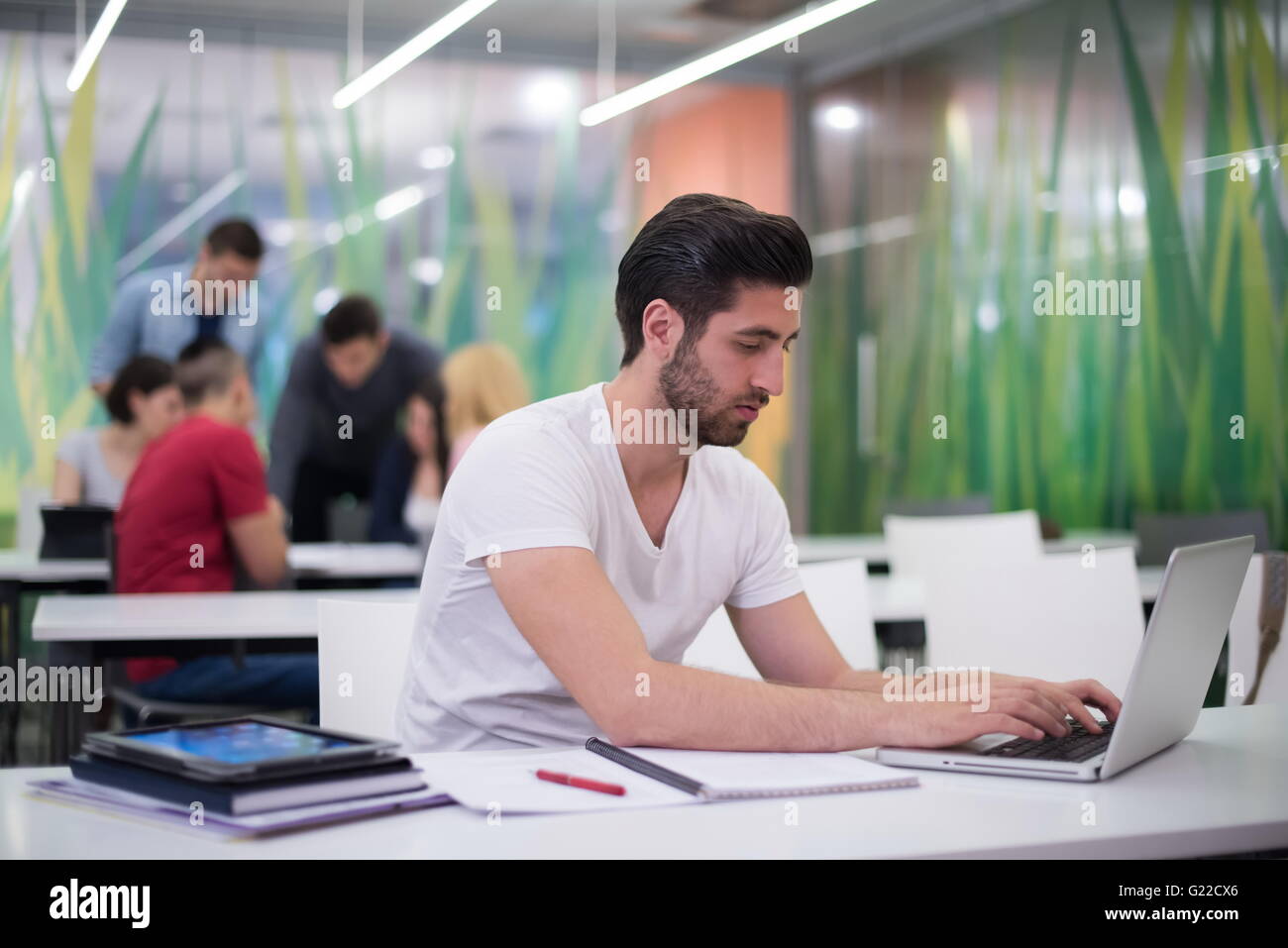 male student in classroom working homework and learning with laptop ...
