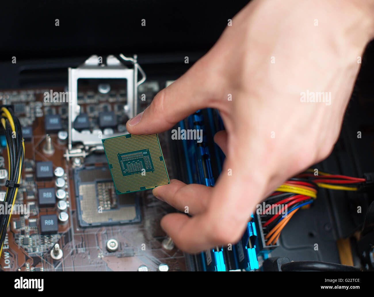 Computer technician installing CPU into motherboard. Stock Photo