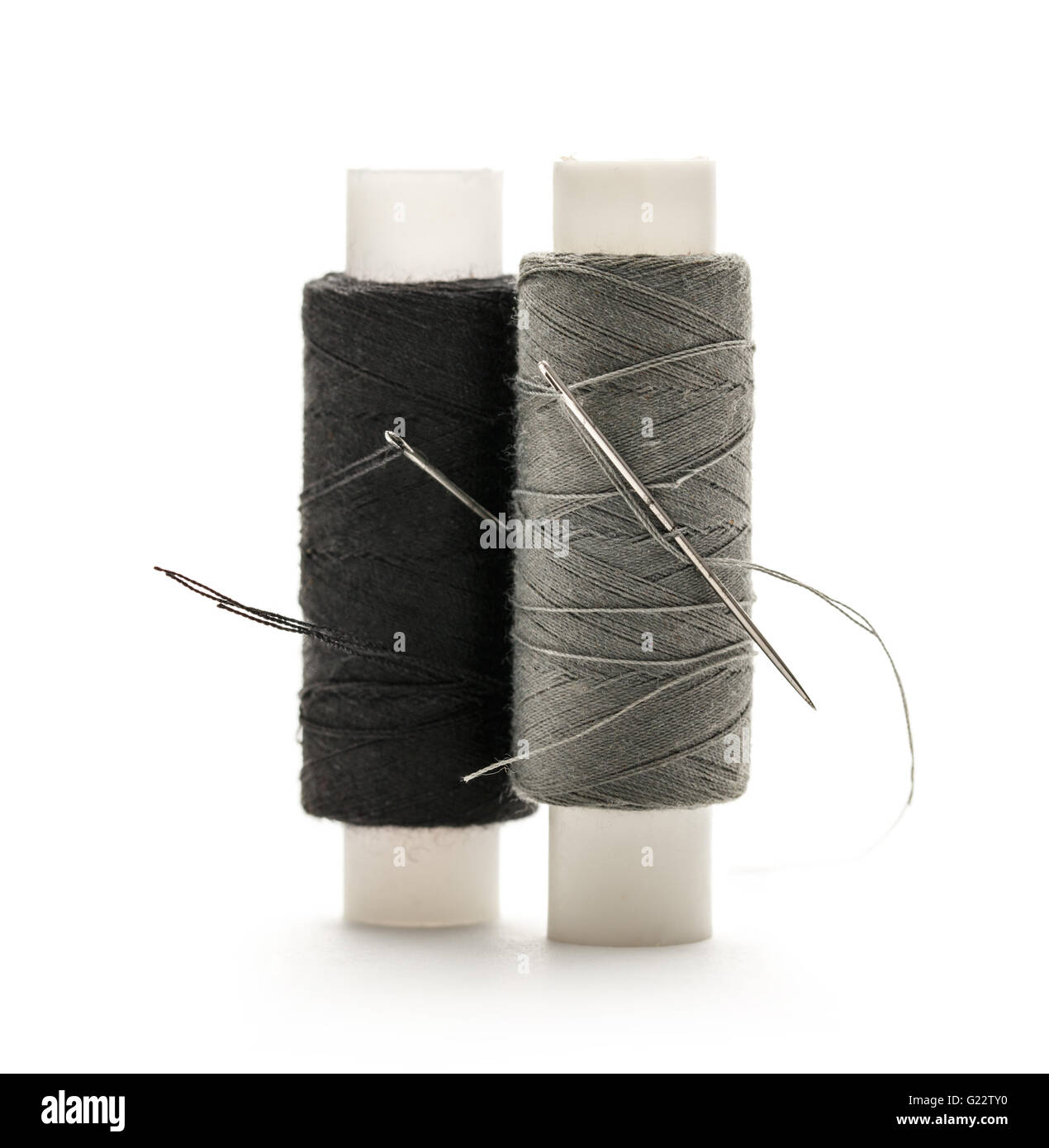 Thread bobbins and needle on white background Stock Photo - Alamy