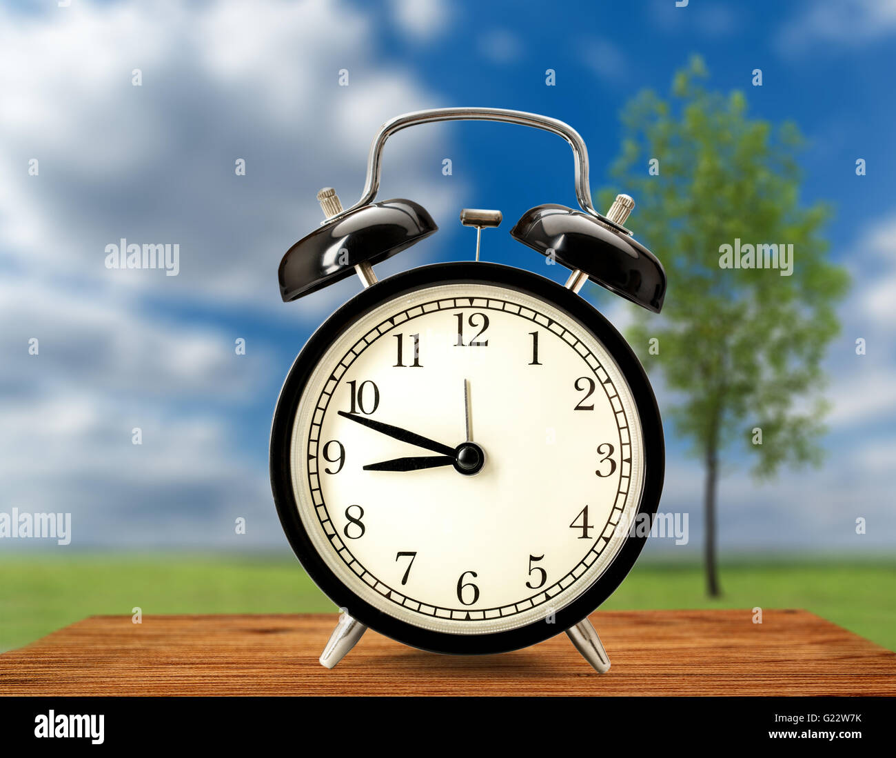 Old fashioned alarm clock on nature background Stock Photo - Alamy