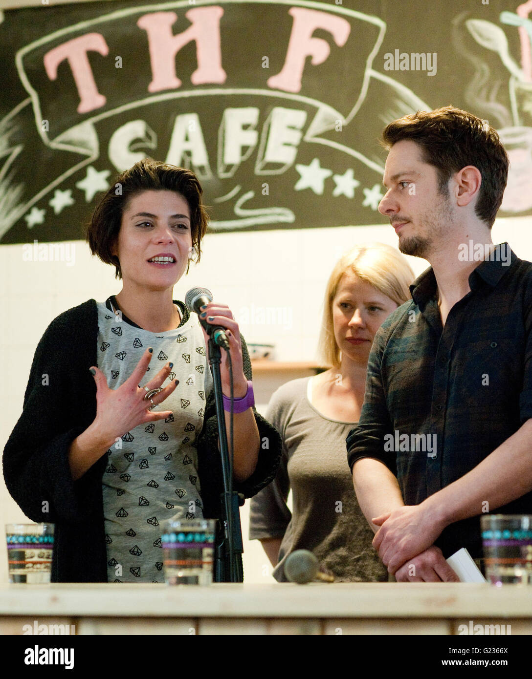Berlin, Germany. 28th Apr, 2016. Sara Turchetto (L-R), Jacqueline Svilarov and Michael Baral, actors and cast members of the German television series 'Lindenstrasse, ' open the THF cafe for refugees in the former Tempelhof airport in Berlin, Germany, 28 April 2016. A cafe and a small library located next to the refugee shelter opened on the same day. Photo: KLAUS DIETMAR GABBERT/dpa/Alamy Live News Stock Photo