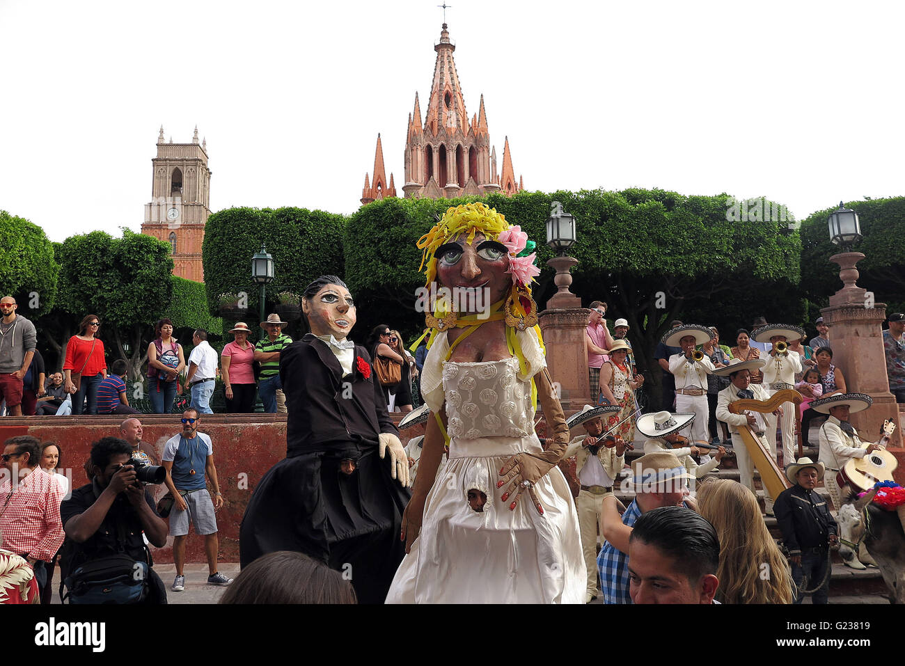 San Miguel De Allende, Mexico. 18th Apr, 2016. A wedding parade marches through the streets in San Miguel de Allende. The wedding parade is complete with ceremonial donkey, a mariachi band and giant paper mache effigies (mojigangas). (Credit Image: © Julie Rogers/via ZUMA Wire) Stock Photo