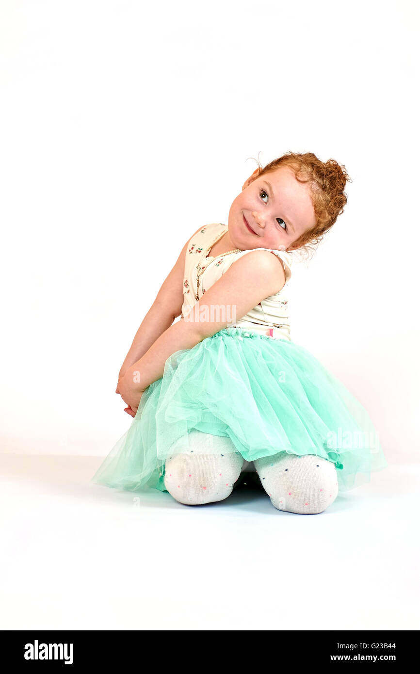 Fashion little girl in green dress, in catwalk model pose, stock photo
