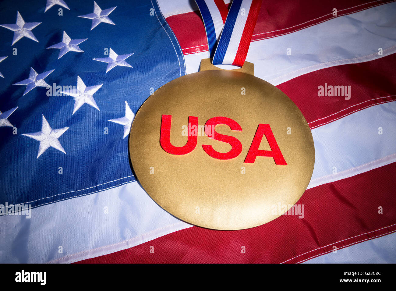Large USA gold medal with red, white, and blue ribbon on textured stars