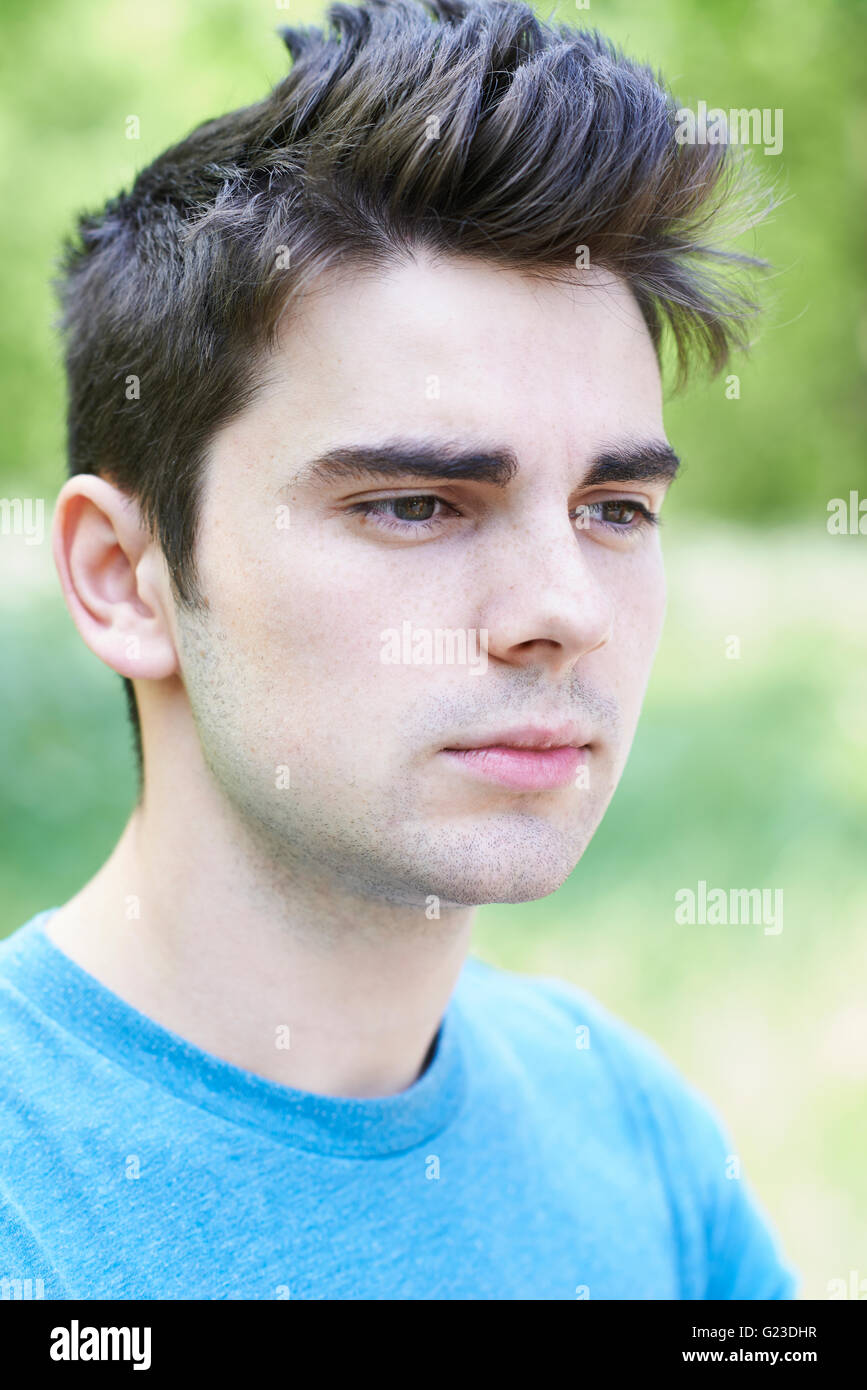 Outdoor Head And Shoulders Portrait Of Serious Young Man Stock Photo