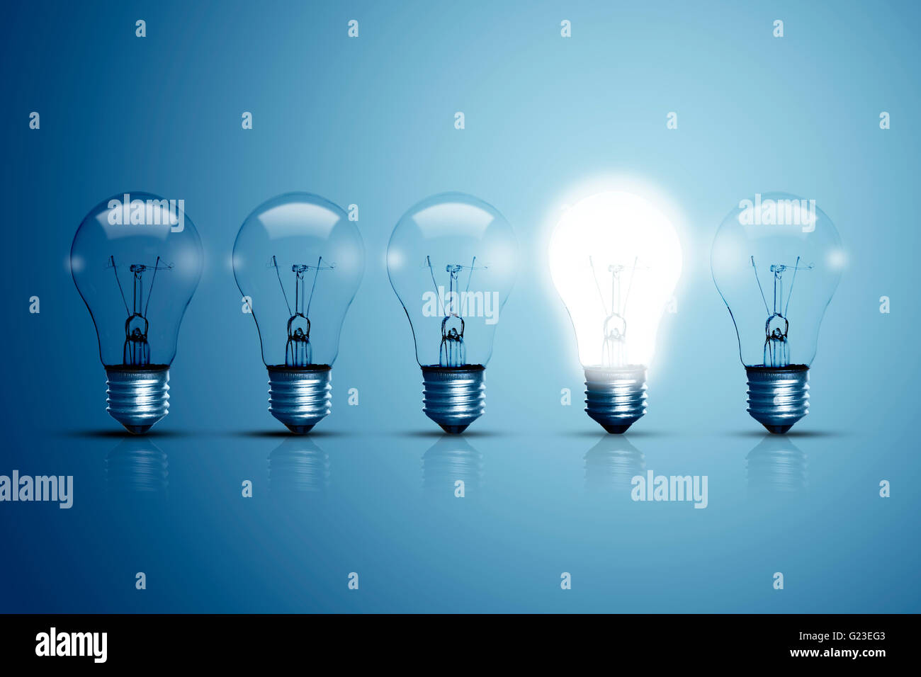 Five bulbs on a blue background and one of them is glowing Stock Photo ...