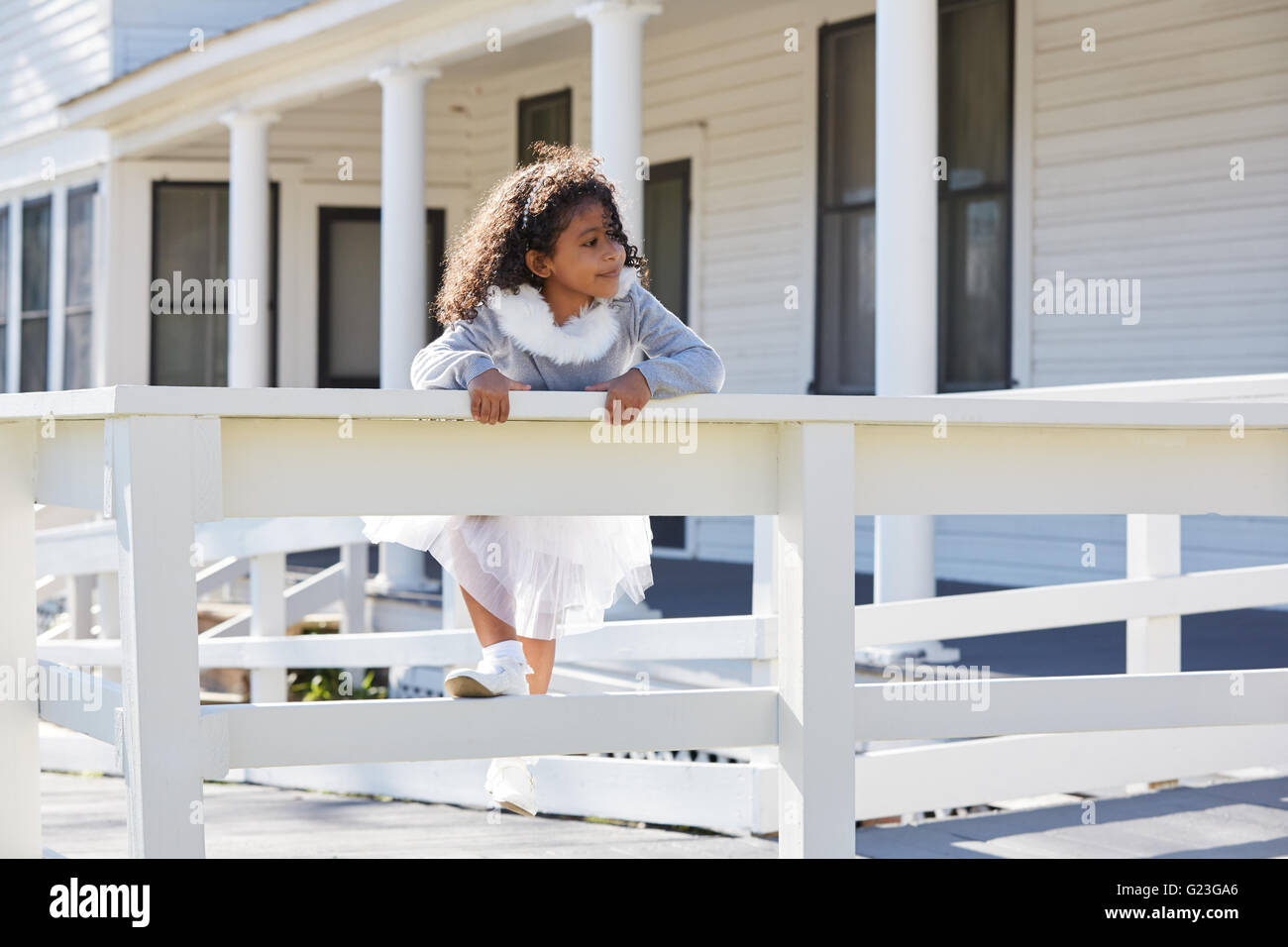 kid toddler girl playing climbing a fence outdoor latin ethnicity Stock Photo