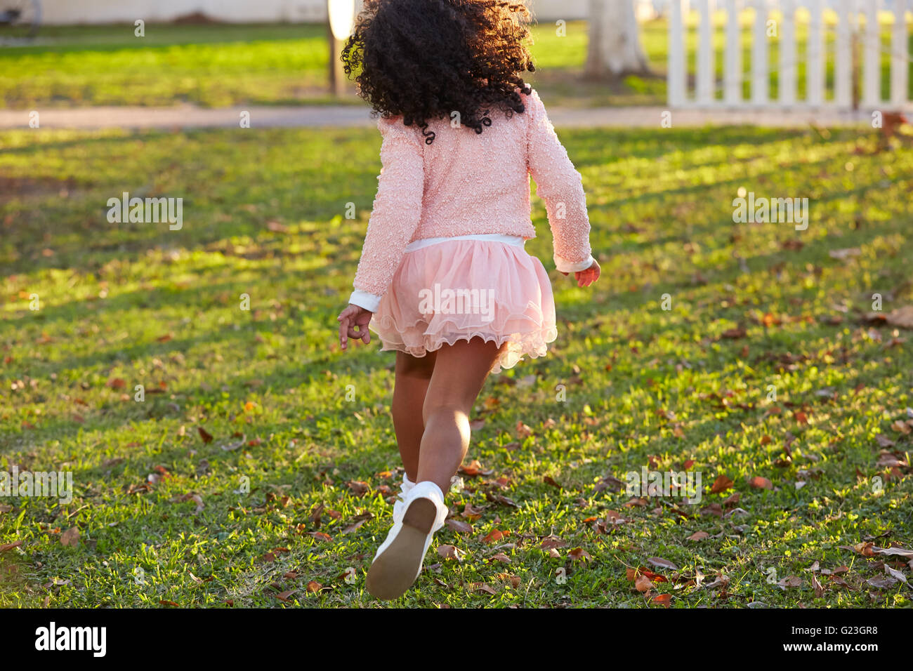 kid girl toddler playing running in park rear view latin ethnicity