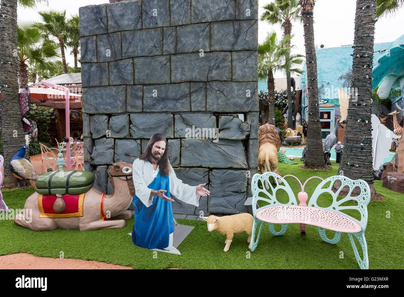 A cardboard cutout of jesus with a plastic sheep at the holy land
