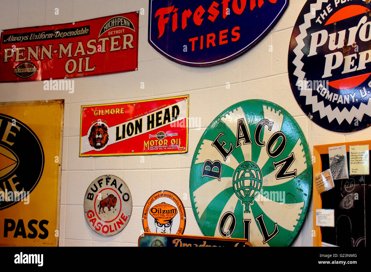 Gasoline, motor oil, and tire advertisement signs hanging on a garage wall at Heritage Park, Alberta, Canada Stock Photo