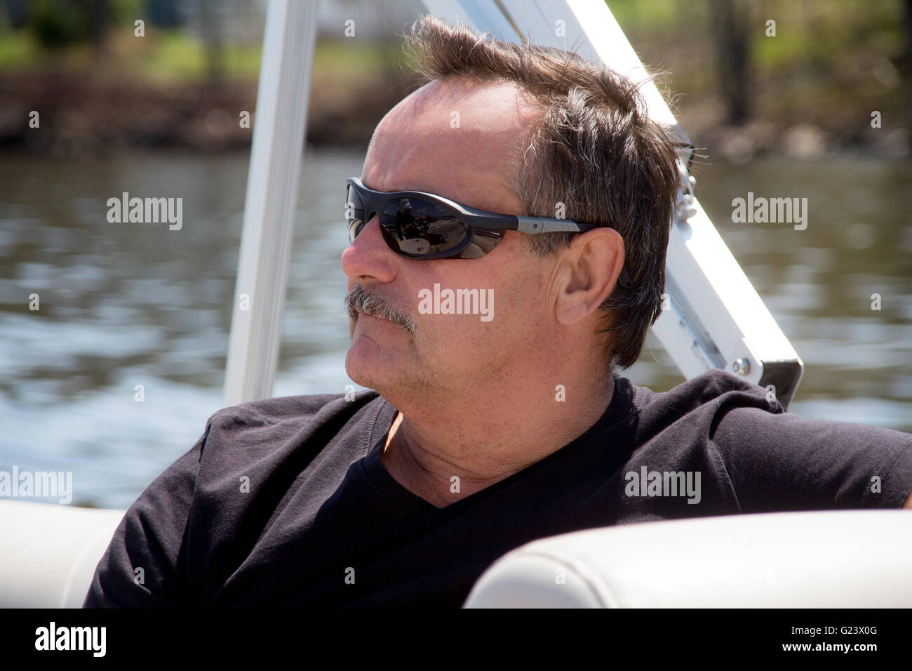 men portrait relaxing with sunglasses on a boat at summer Stock Photo