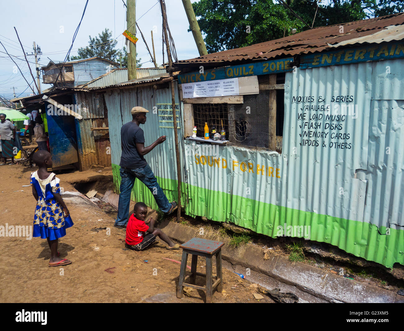 A signwriter paints a shop in Kibera, Nairobi, Kenya Stock Photo