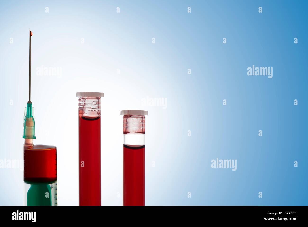 Syringe and two vials of blood on blue background. Horizontal