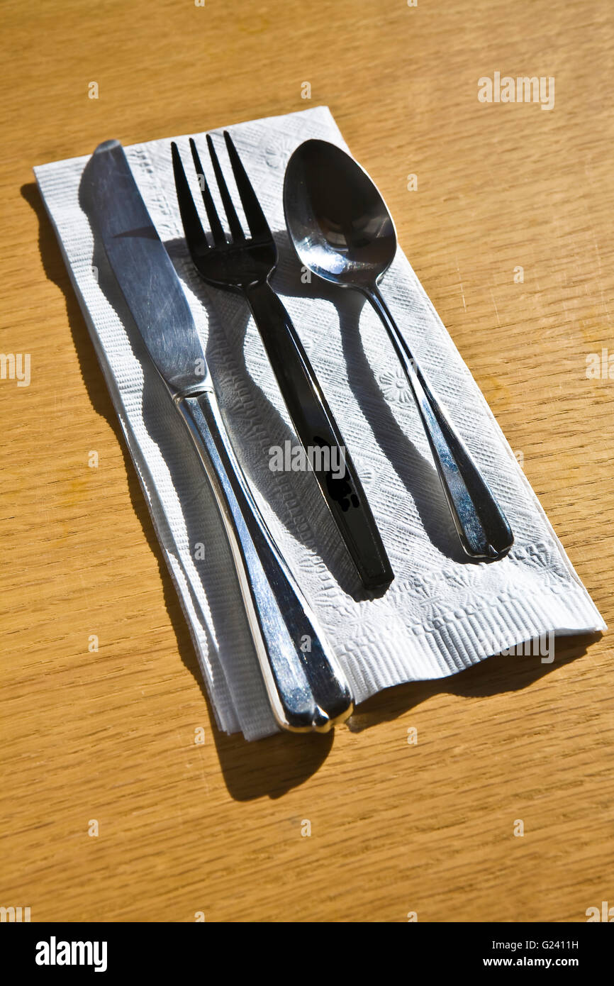 Knife, fork, and spoon on white napkin on wooden table Stock Photo Alamy