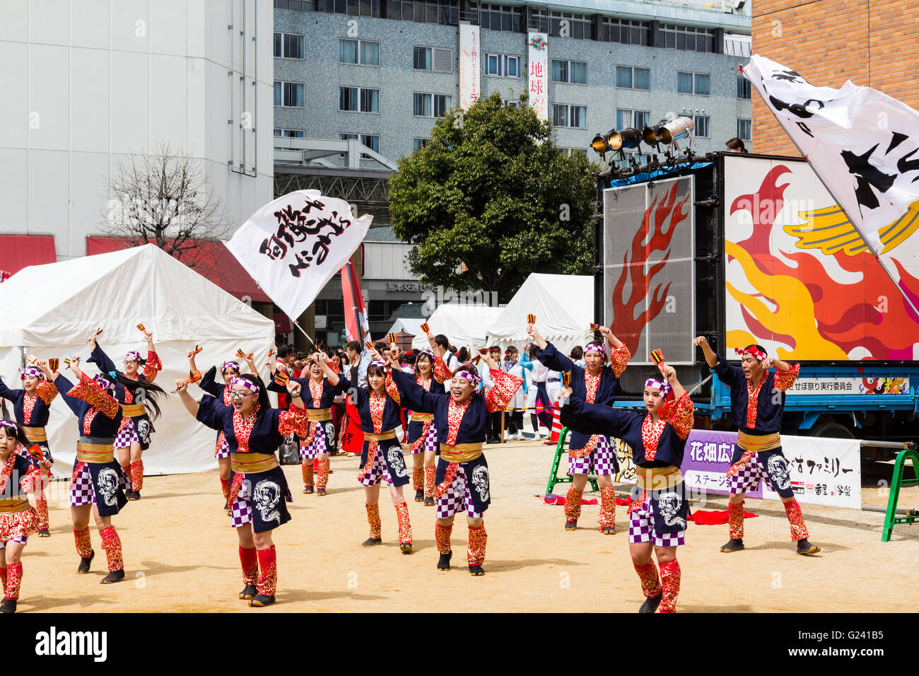 Japanese Hinokuni Yosakoi dance festival. Formation of children and teenage dancers in public square dancing wearing colourful yukata jackets. Stock Photo