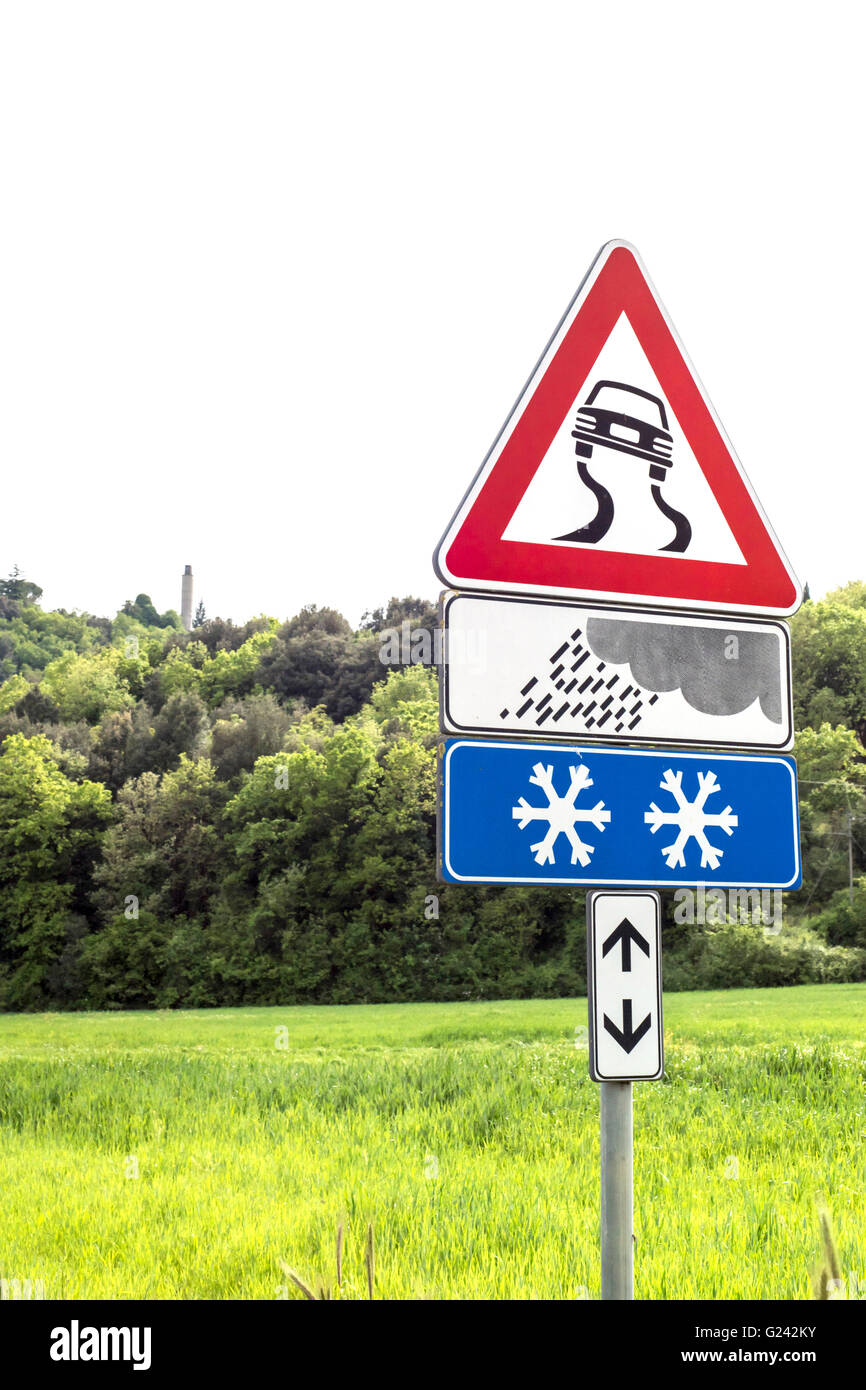 Road Sign Caution curves ahead in the meadow Stock Photo