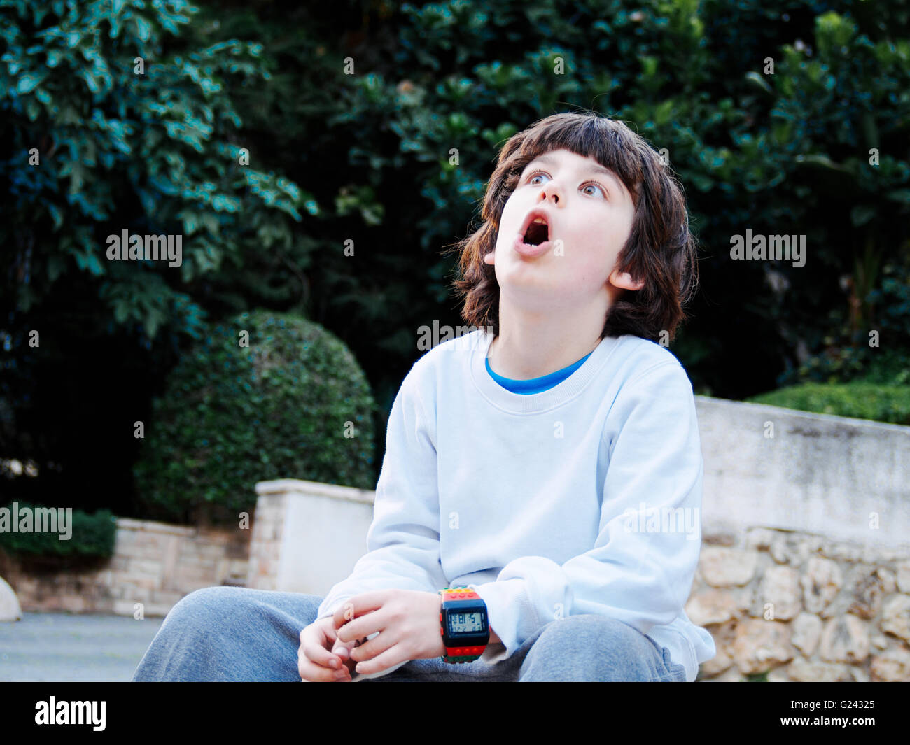 young boy of seven, looks up in awe Stock Photo