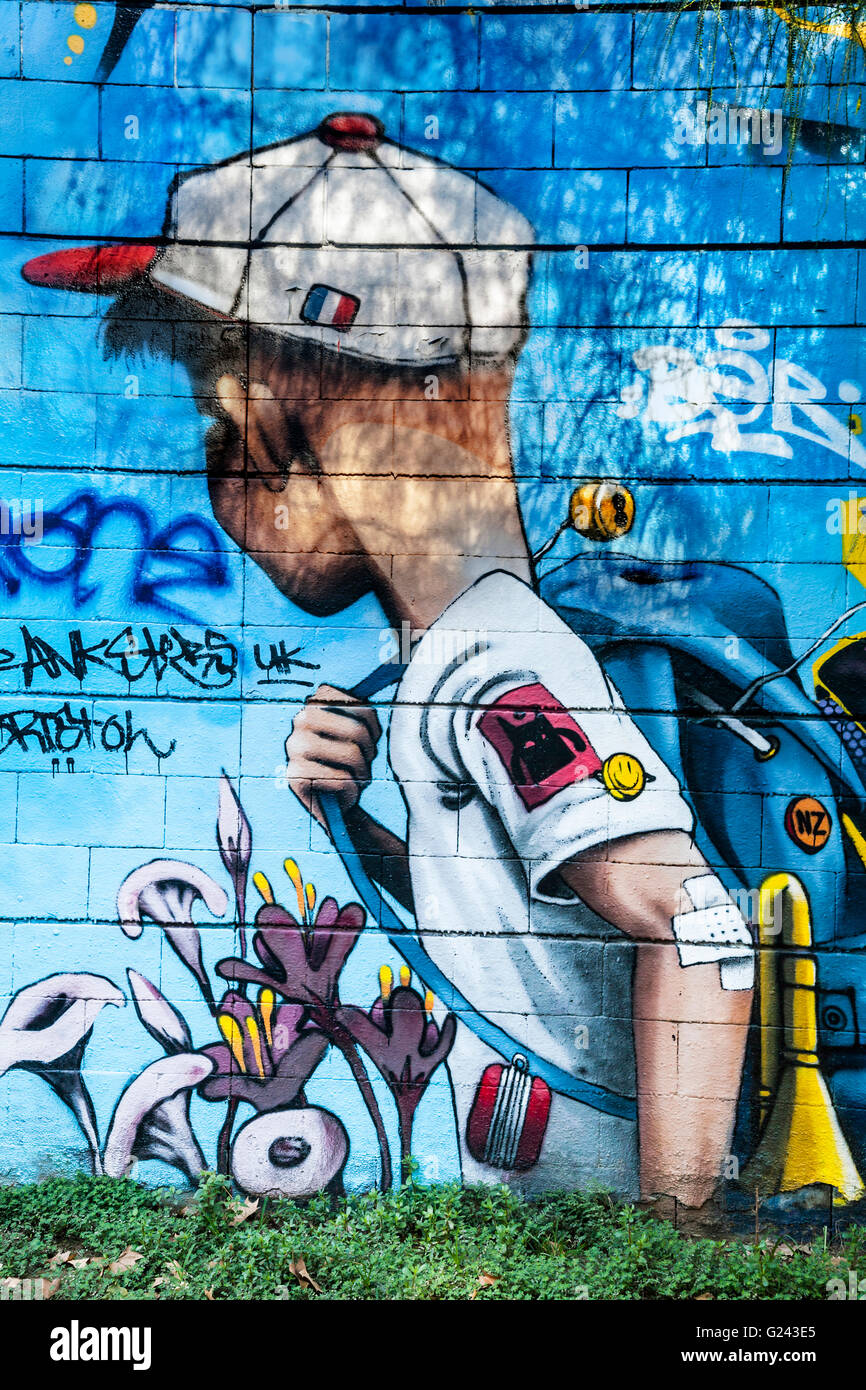 Graffiti Detail of A Boy Carrying A Bag And Wearing A Cap on a wall, Barcelona, Catalonia, Spain. Stock Photo