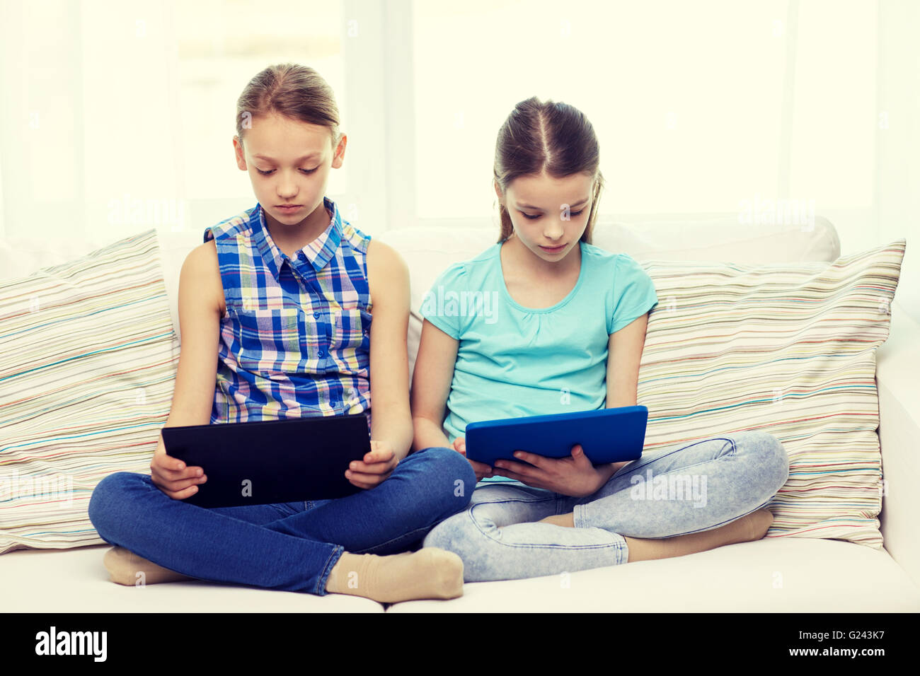 girls with tablet pc sitting on sofa at home Stock Photo - Alamy