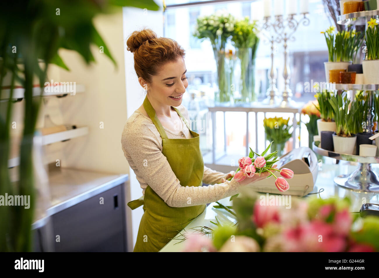 smiling florist woman making bunch at flower shop Stock Photo - Alamy