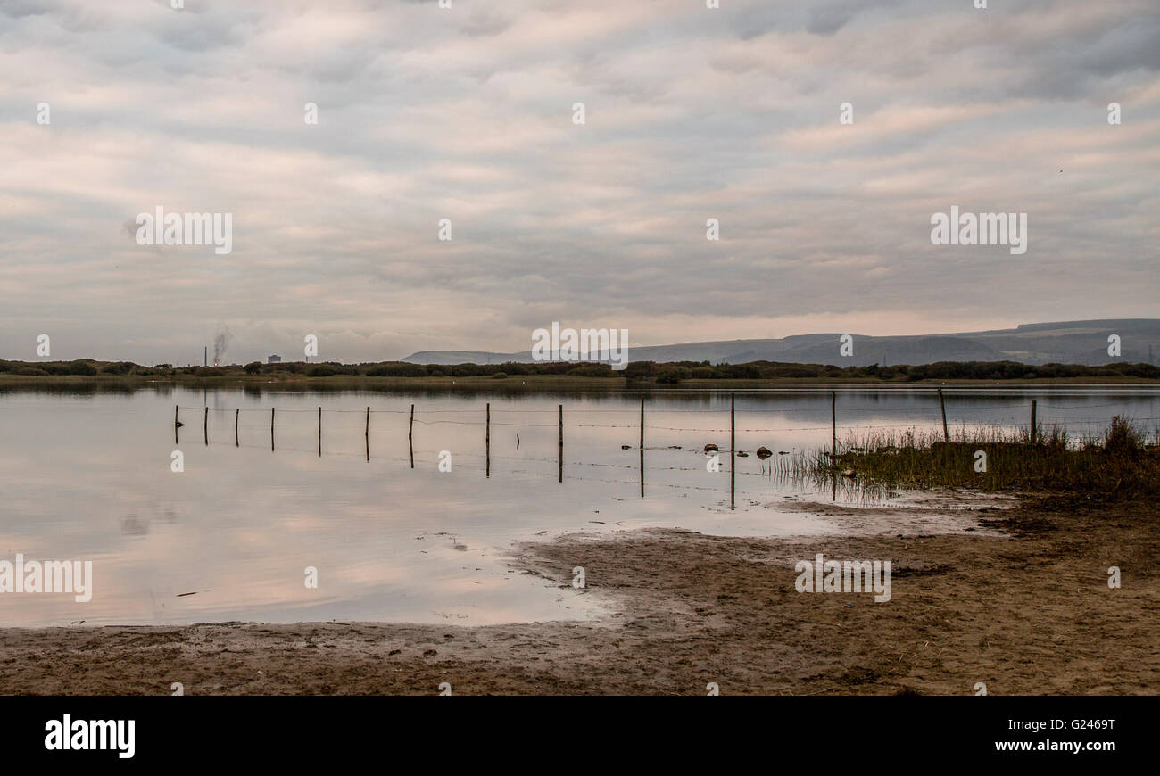 Port Talbot steel works is pictured far left beyond Kenfig Nature Reserve in South Wales, UK. Stock Photo