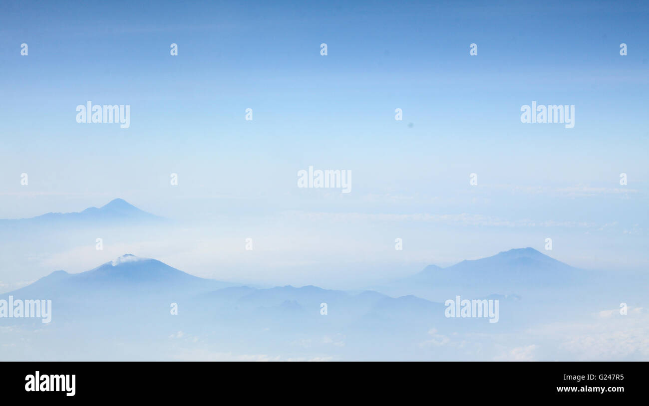Aerial view of blue sky with clouds and fog around the Mountains Stock ...