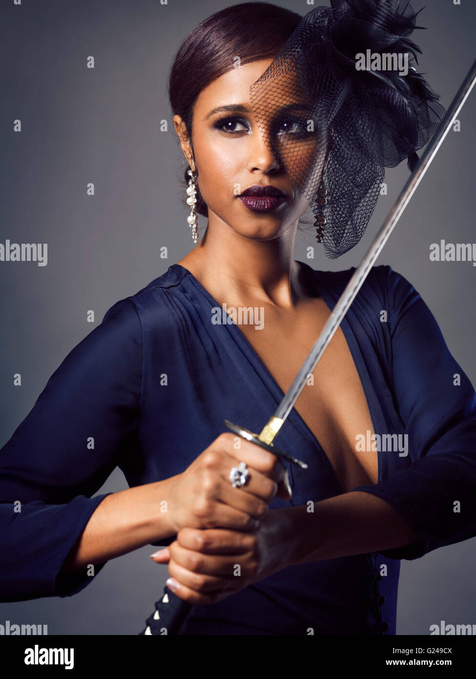 Woman with black veil holding a Katana sword in her hands Stock Photo