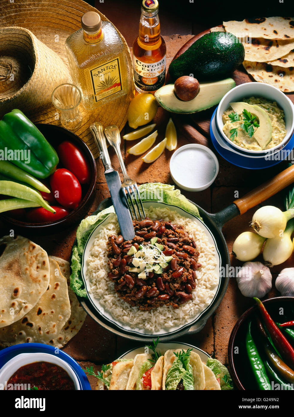 Mexican national cuisine, quesadillas, stuffed tortillas, guacamole, chili con carne with rice, tequila, Corona beer Stock Photo
