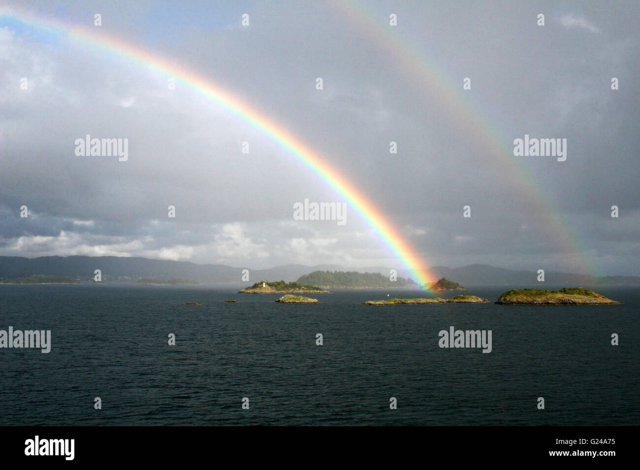 Double rainbow over islands as leave Bergen Stock Photo