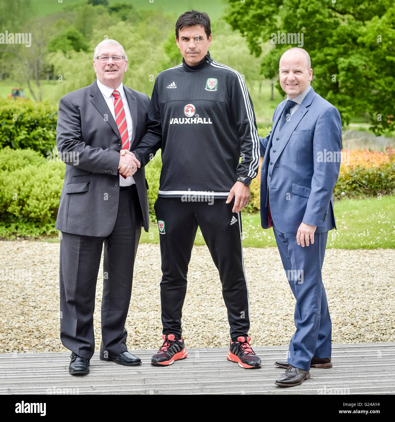Wales' national football team manager Chris Coleman (centre) shakes hands with Football Association Wales President David Griffiths (left) and Football Association Wales Chief Executive Jonathan Ford after a press conference at The Vale Resort, Hensol. Stock Photo