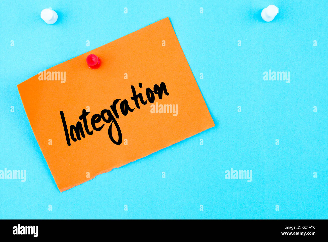 Integration written on orange paper note pinned on cork board with ...