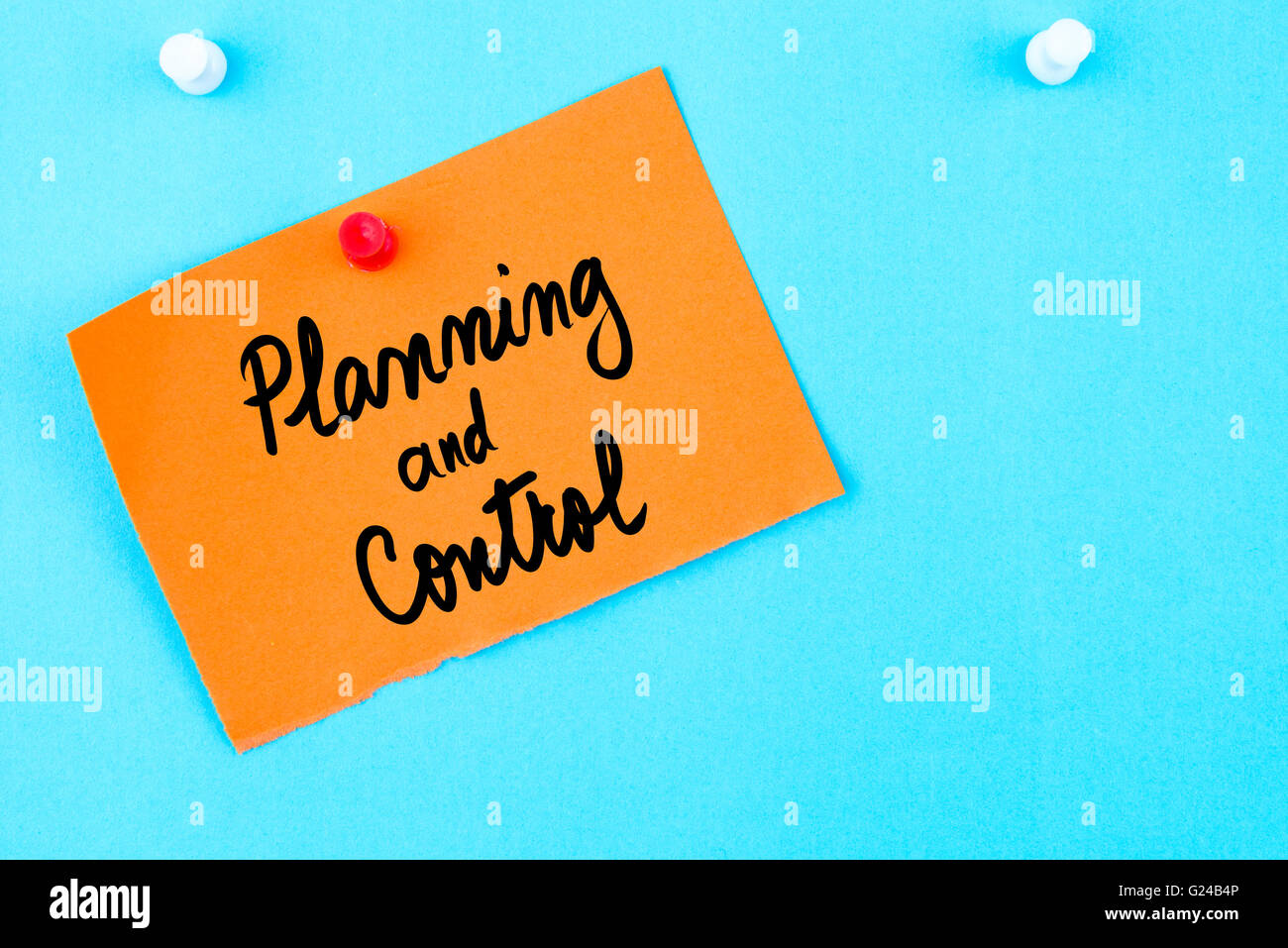 Planning and Control written on orange paper note pinned on cork board ...