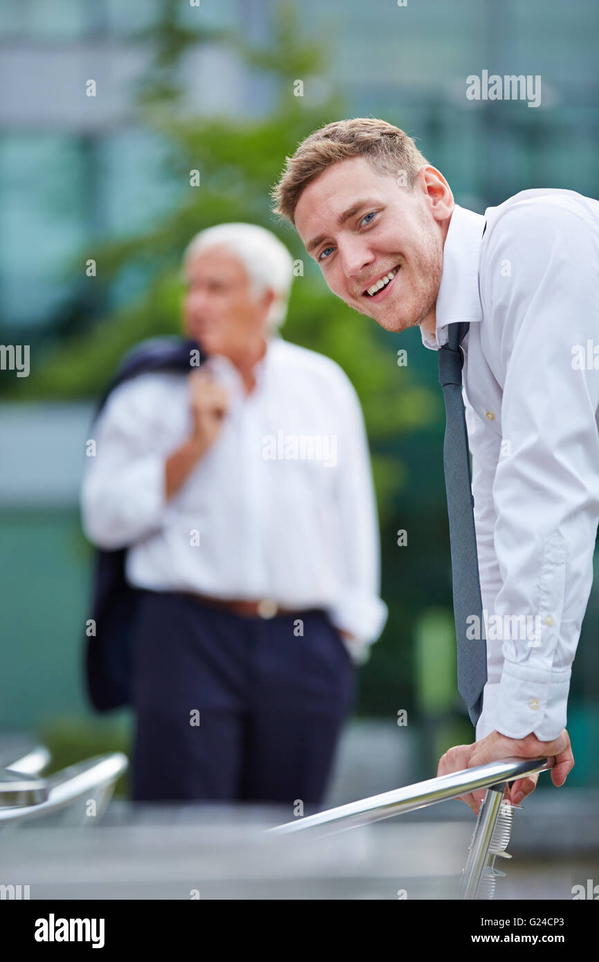 Smiling trainee in business attire standing in the city Stock Photo