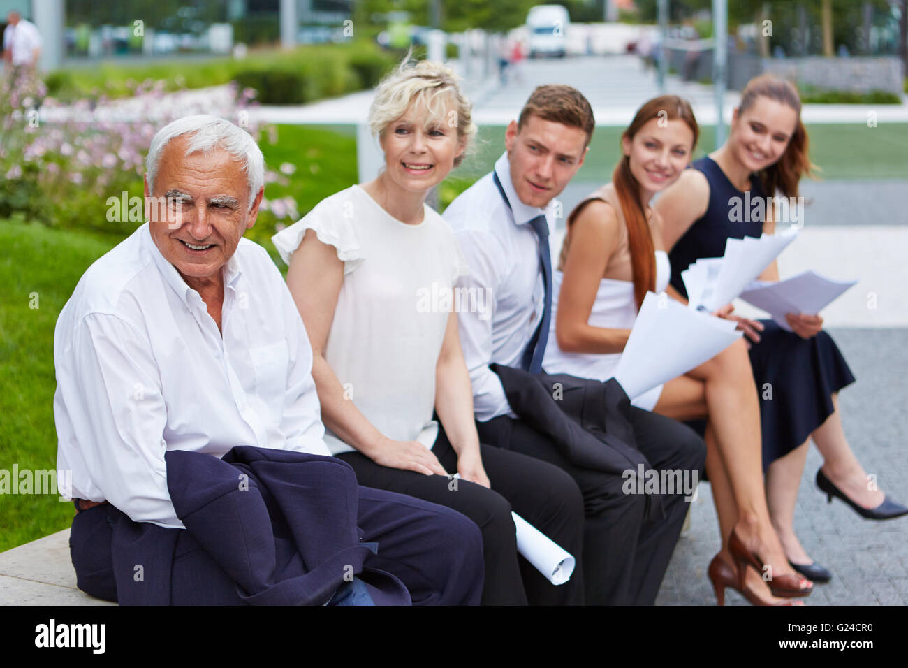 Application candicates waiting for job interview outdoors in front of office Stock Photo