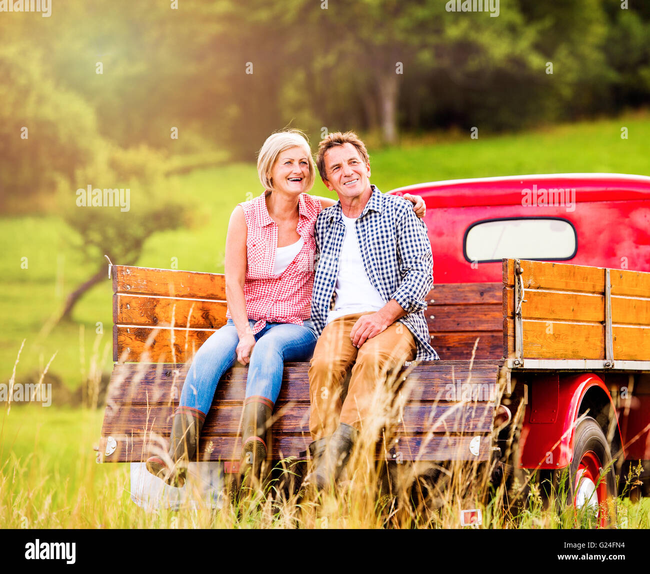 Senior couple sitting in back of red pickup truck Stock Photo - Alamy