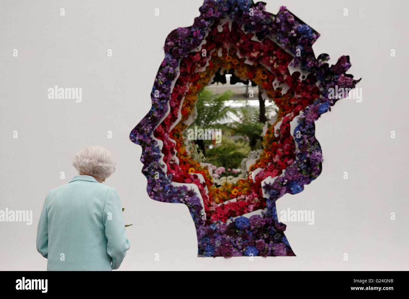 Queen Elizabeth II looks at a floral exhibit by the New Covent Garden Flower Market, which features an image of the Queen, during a visit to the RHS Chelsea Flower Show, at the Royal Hospital Chelsea, London. Stock Photo