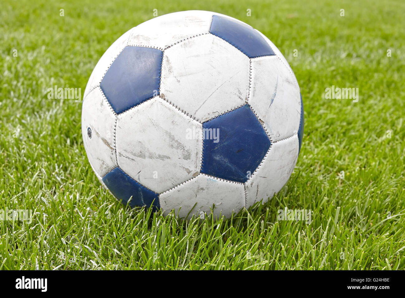 Close up picture of a used leather soccer ball on grass. Stock Photo