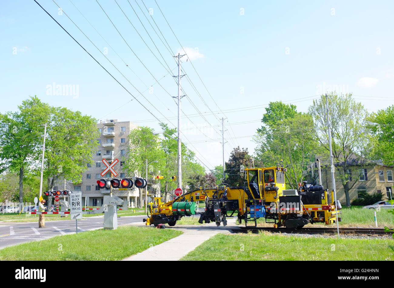 A railway vehicle crossing a road in London, Ontario in Canada. Stock Photo