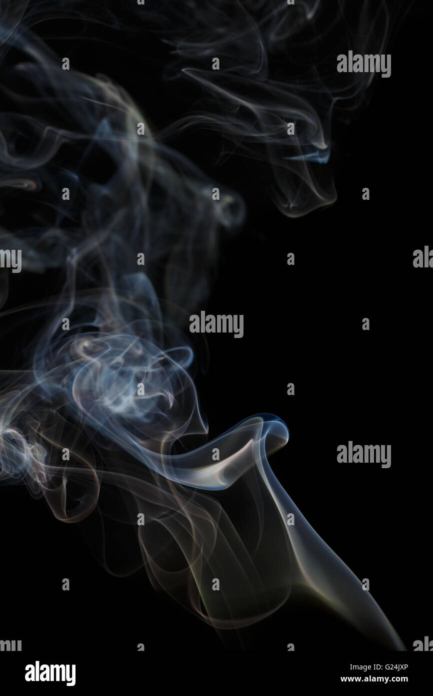 Abstract art. Color blue smoke from the aromatic sticks on a black