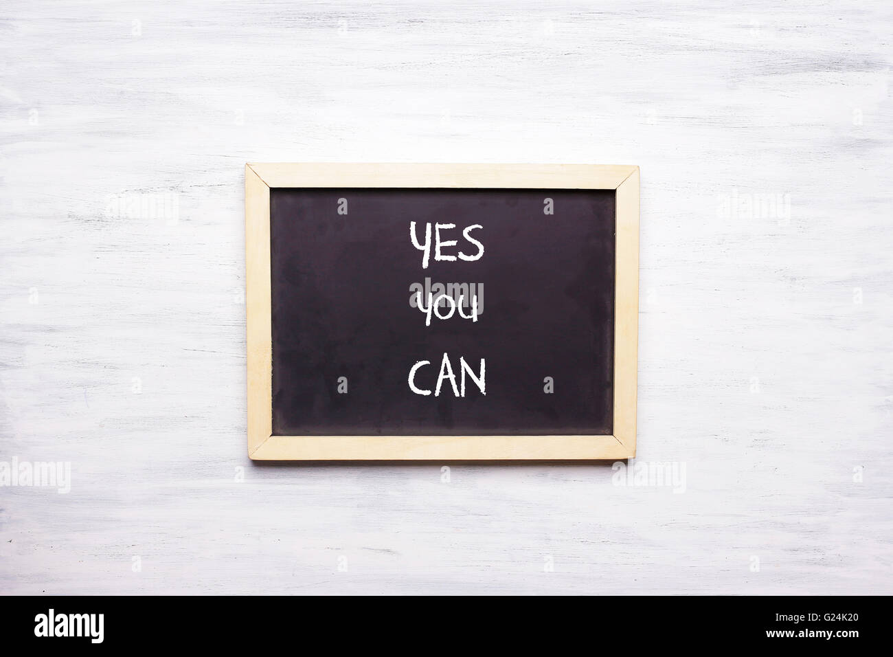 Top view of chalkboard with quote YES, YOU CAN written on it. Motivation and leadership concept. Stock Photo