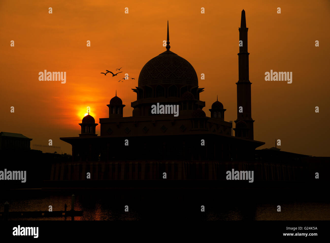 Silhouette of Putrajaya red mosque during sunrise in Malaysia Stock Photo