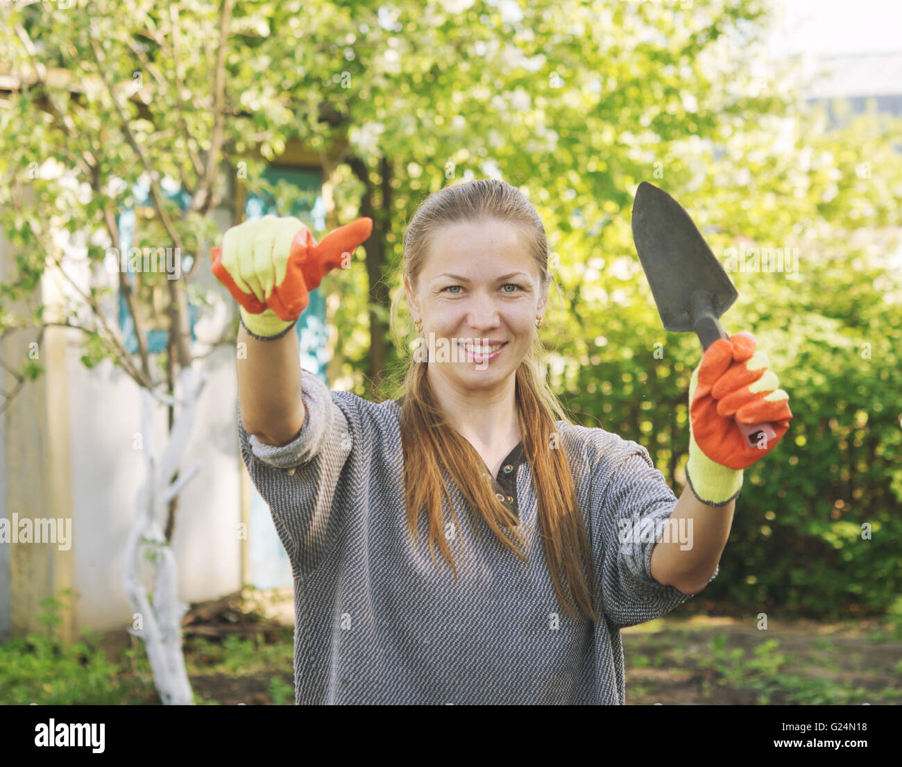 young beautiful female gardener with thumb up Stock Photo