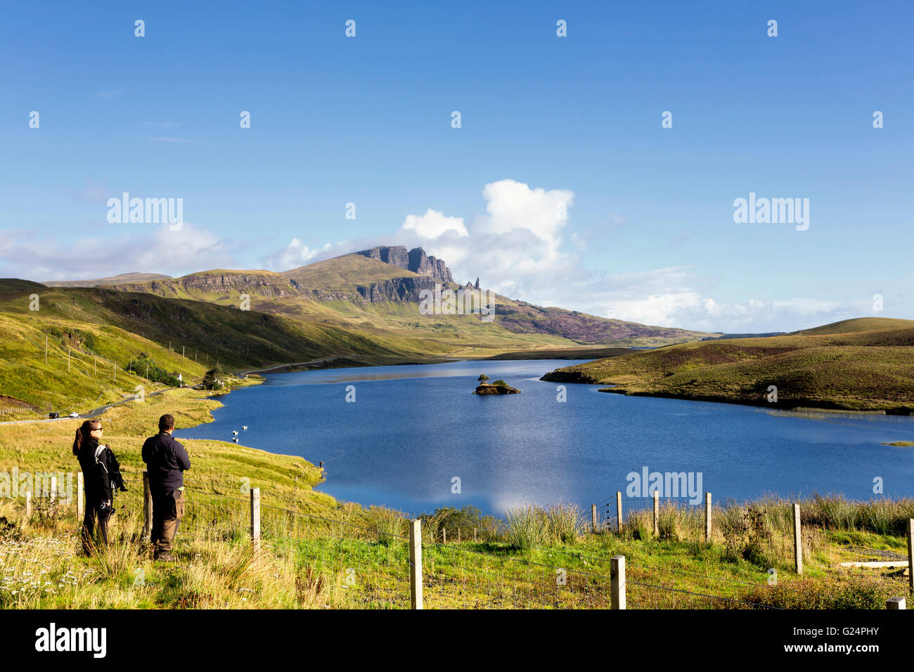A couple watching the beautiful landscape of Old Man of Storr in the Trotternish Peninsula, Isle of Skye, Inner Hebrides, Scotland, United Kingdom Stock Photo