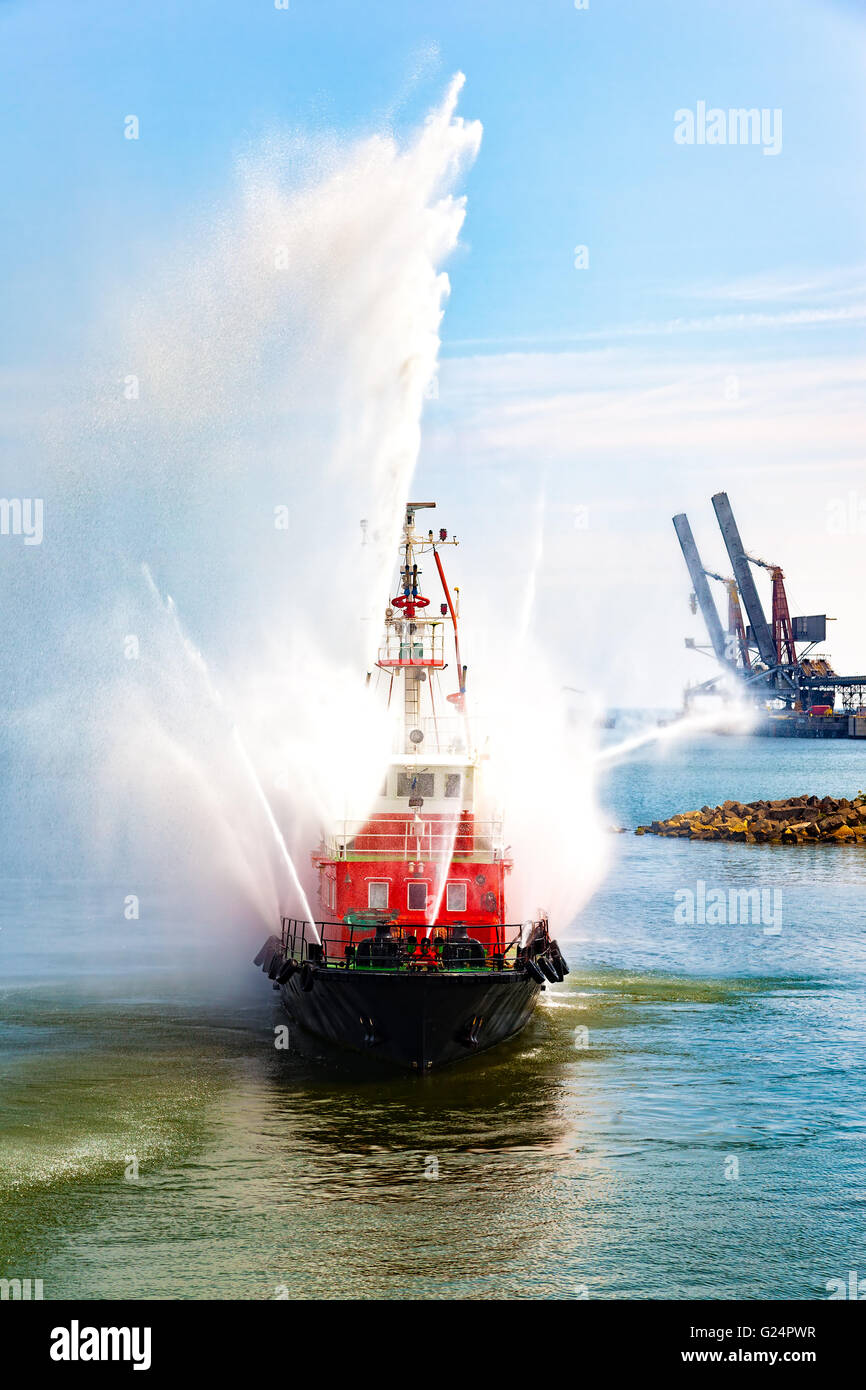 Fire fighting boat sprays water in port Stock Photo Alamy