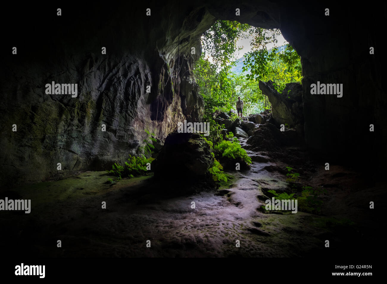 A man standing and looking into Tham Kang Cave near Nong Khiaw in Laos Stock Photo