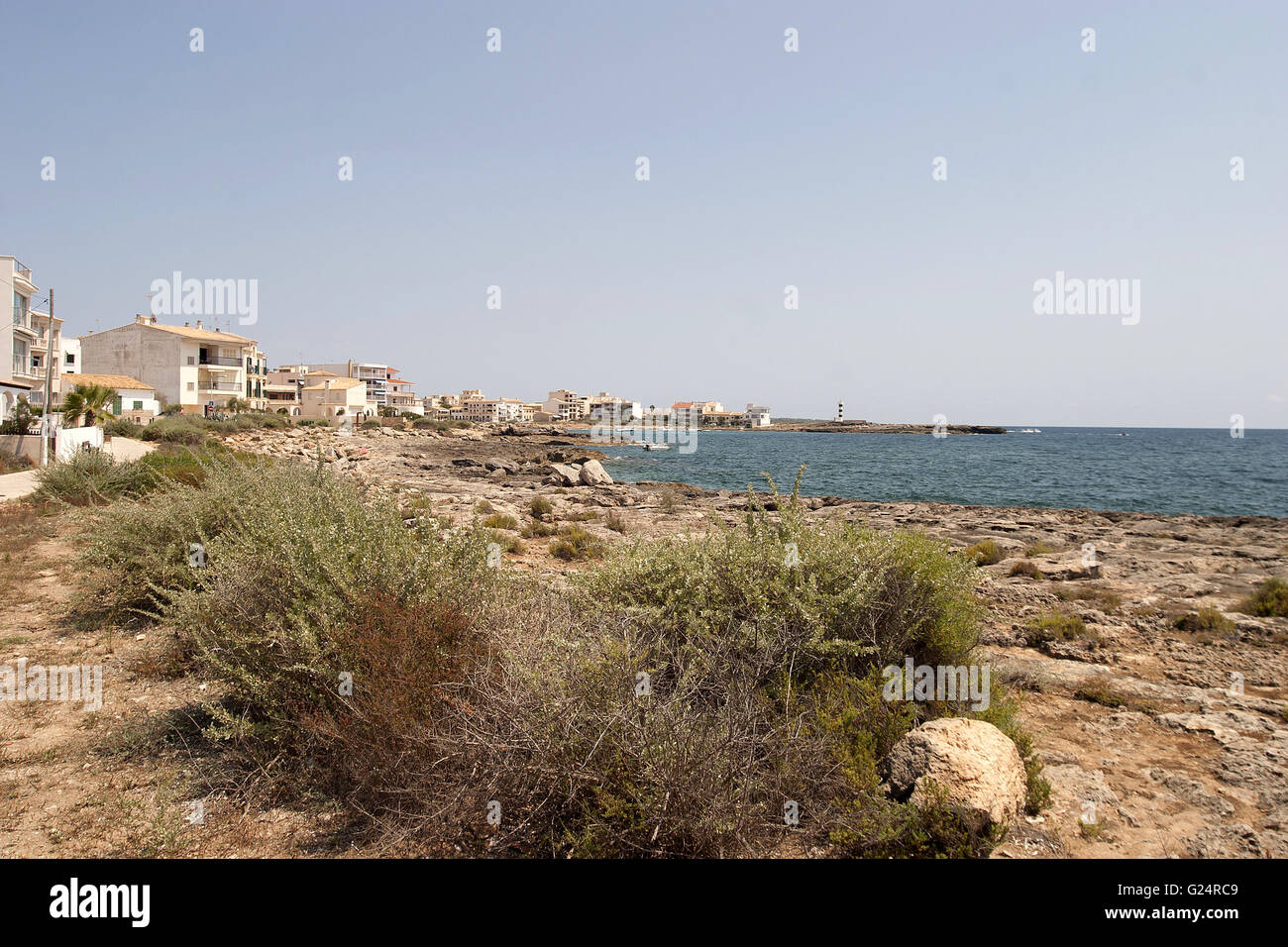 a beautiful wide angle shot of an empty beach of Palma de Mallorca with vegetation and houses in the distance Stock Photo