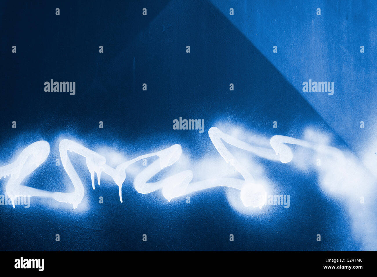White sprayed graffiti on a blue metal background Stock Photo