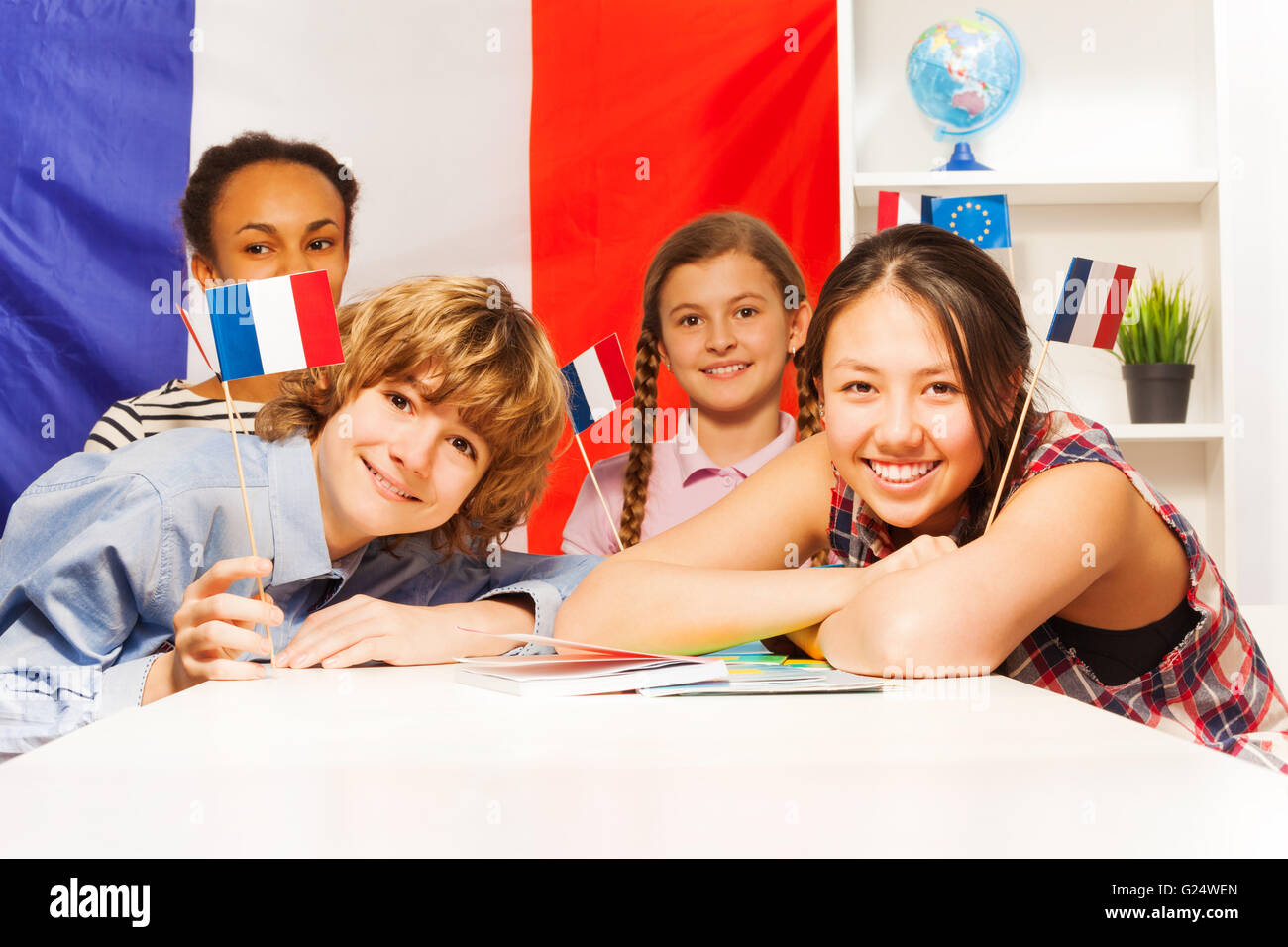 Portrait of happy teenage students holding flags Stock Photo