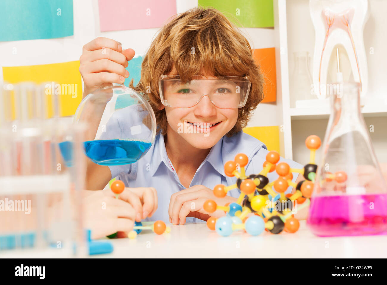 Boy in safety goggles holding flask at the lab Stock Photo