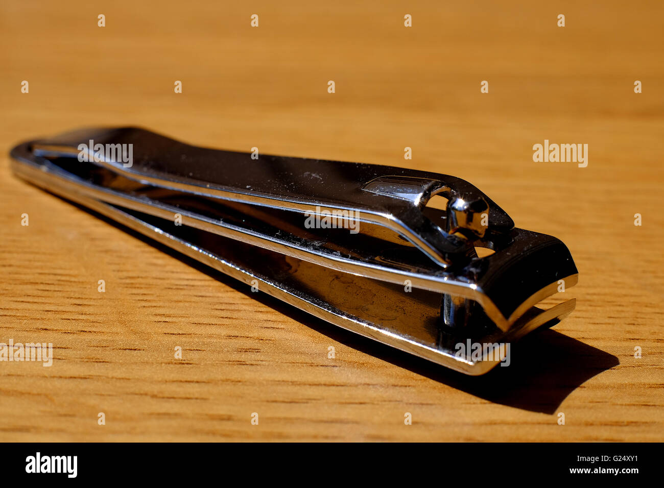 A nail clipper on a wooden table Stock Photo